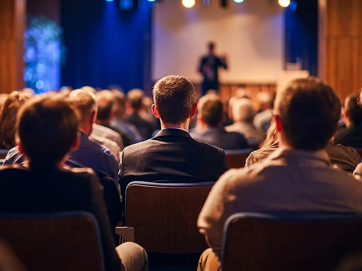 Plateia acompanhando a apresentação em evento de empresa